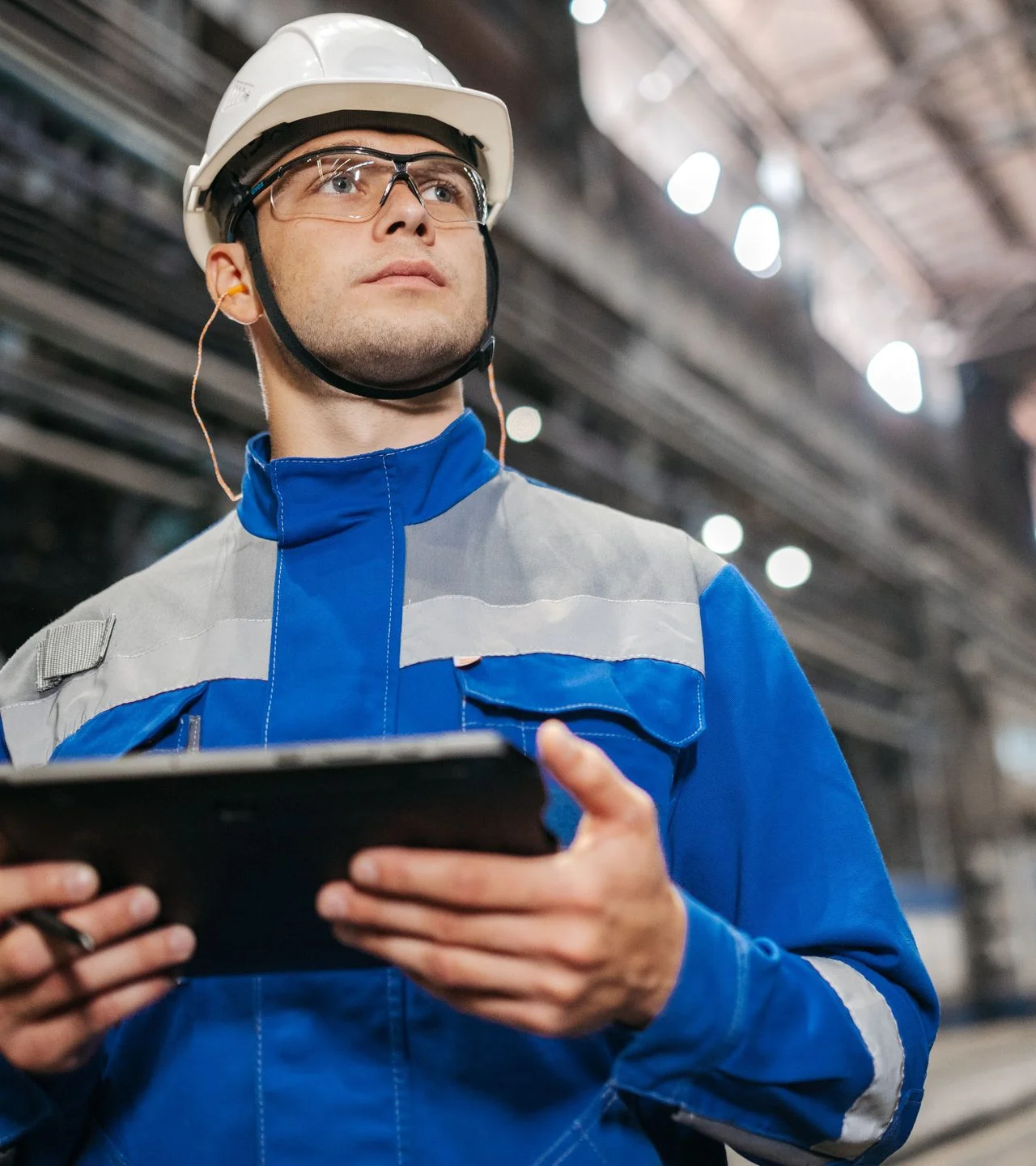 A production worker reviewing data on a tablet on the factory floor