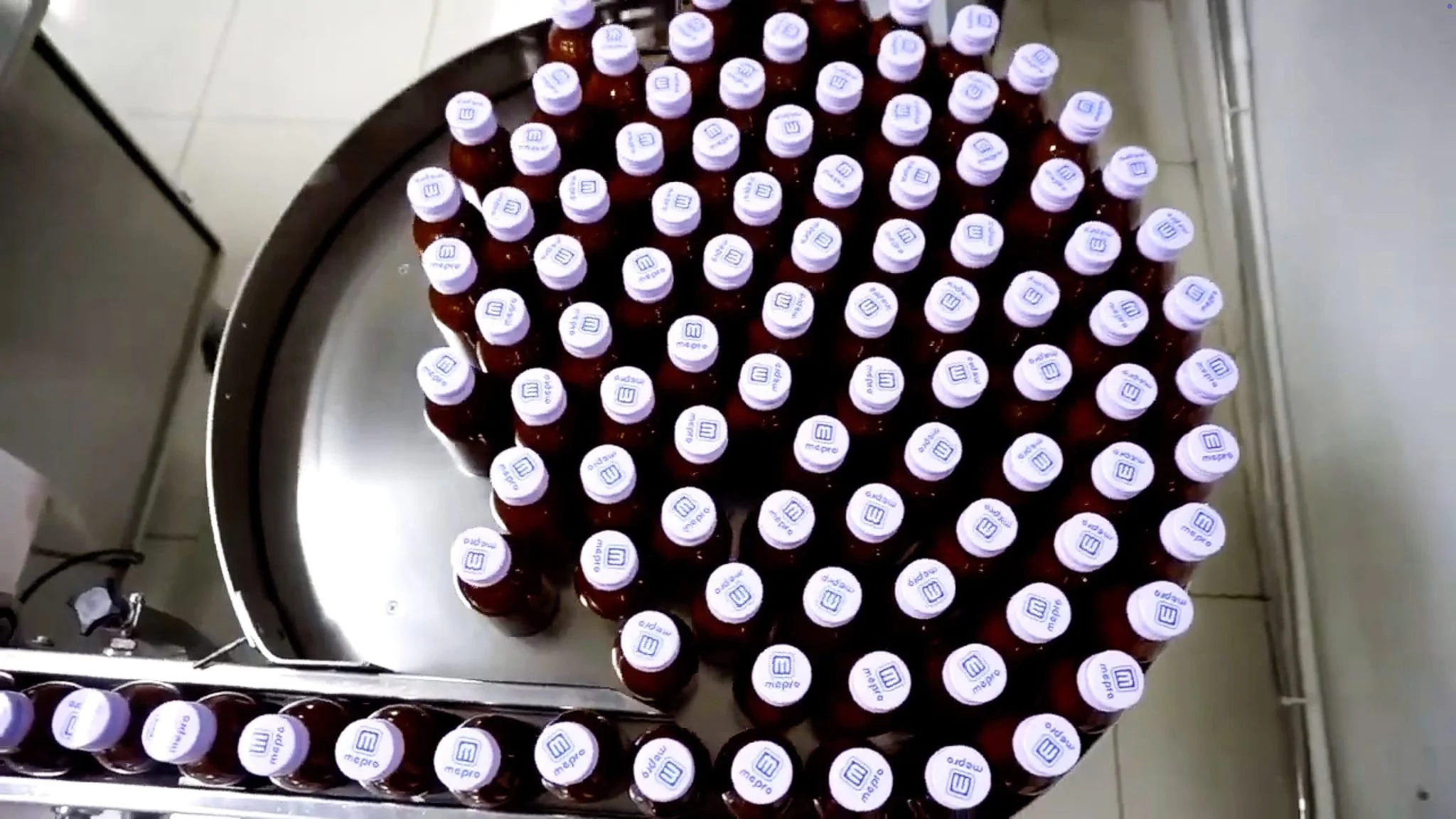 Amber glass bottles with Meprofarm-branded caps on a rotary filling line